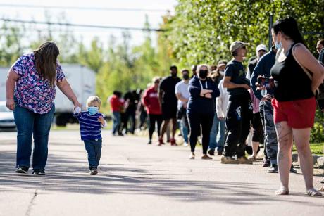 People wait in line at a mass vaccination and testing clinic at the Moncton Coliseum in Moncton, N.B., on Sept. 22.